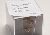 Mot de Nadia sur une pile de papier avec des bagues brunes 